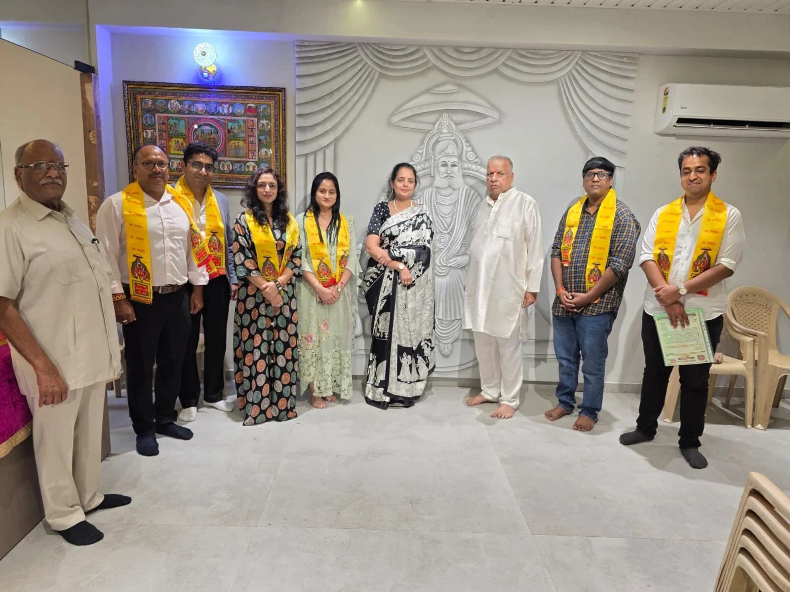 A group photograph in front of the Maharaja Agrasen relief.