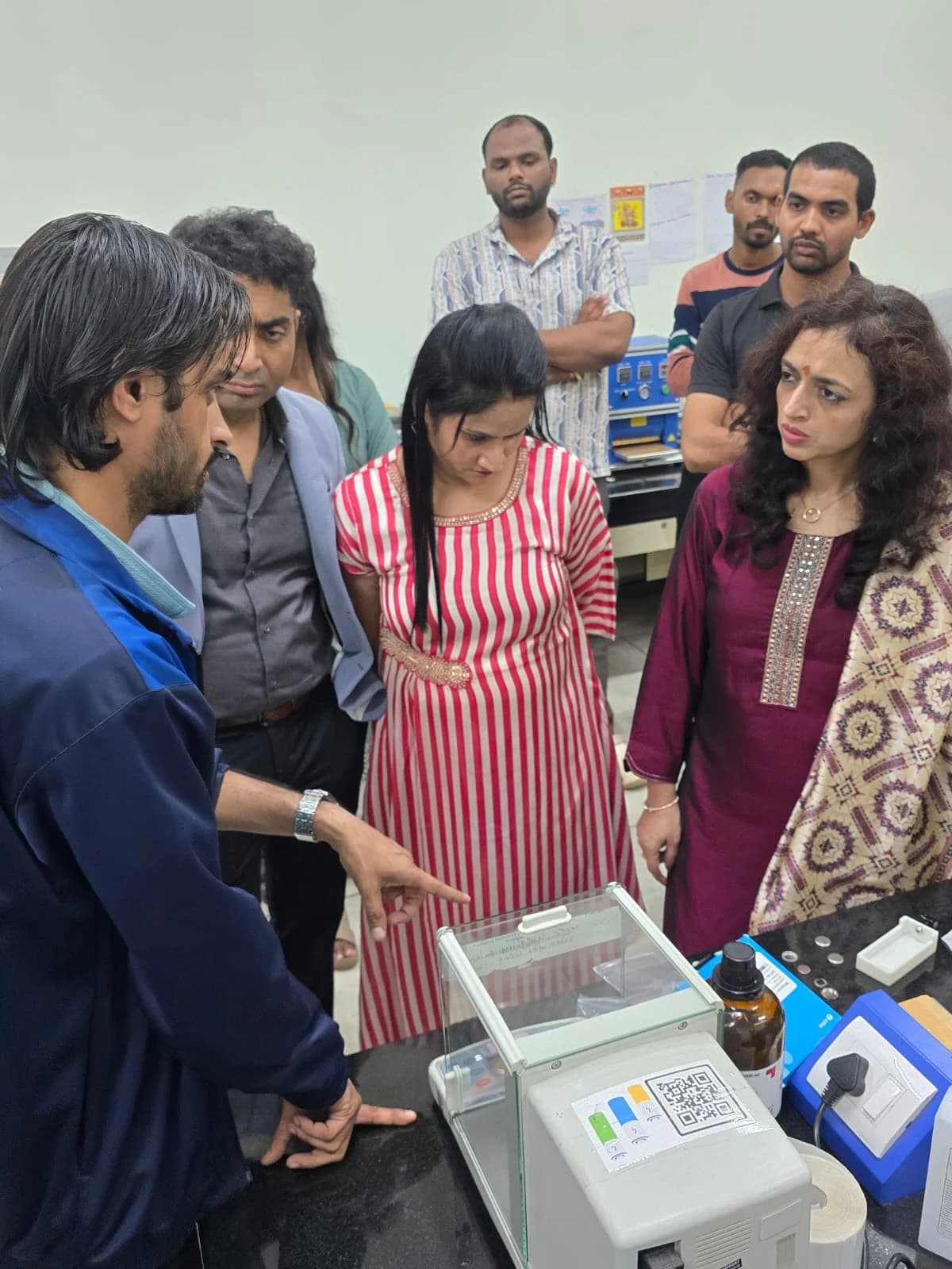 Committee members listening to a laboratory demonstration and examining research samples.