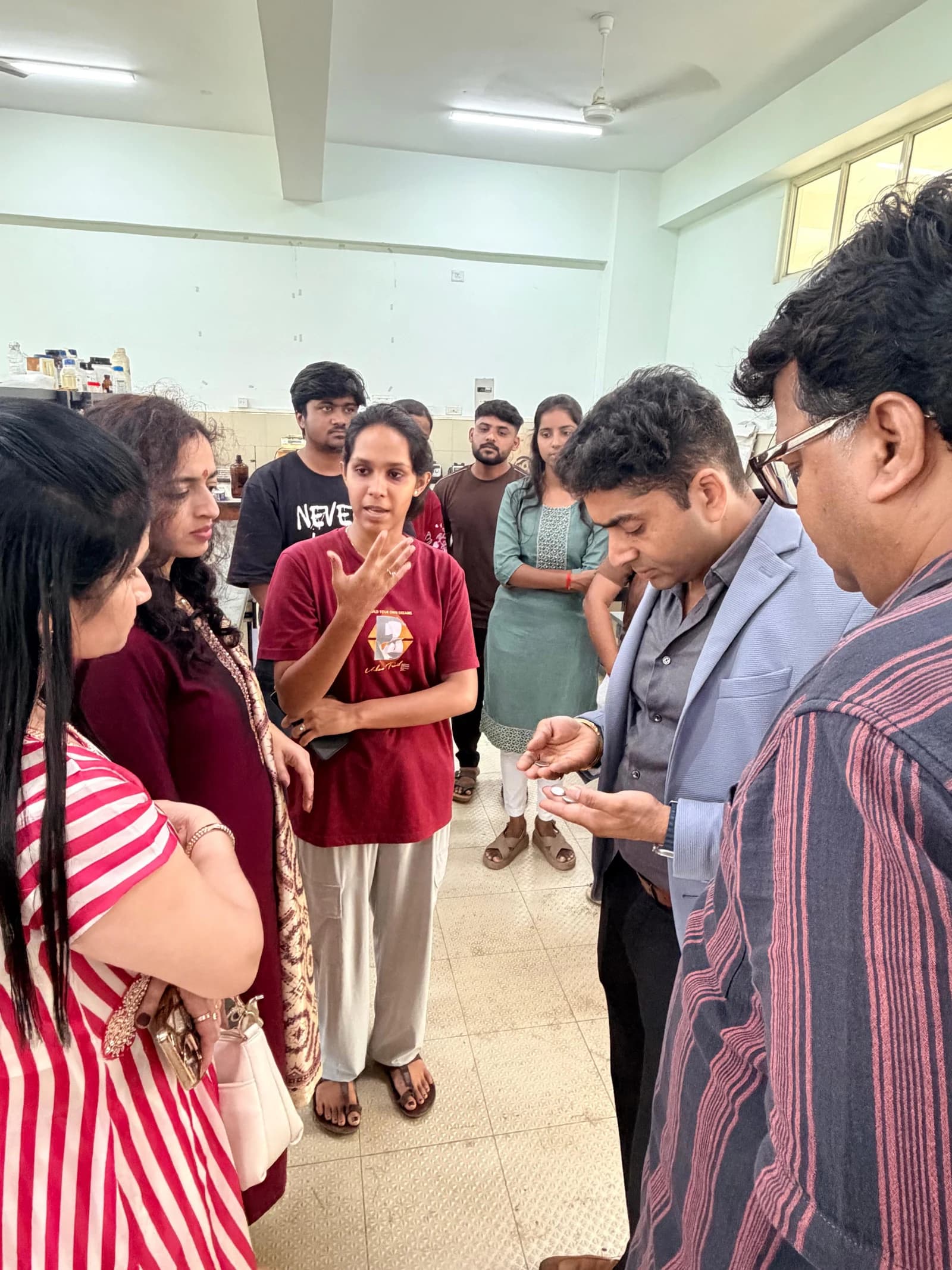 A student sharing research with the visiting committee in the laboratory.
